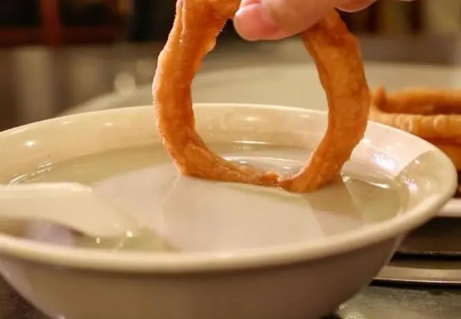 Close-up of Beijing Douzhi, a traditional fermented mung bean drink, showcasing local street food culture