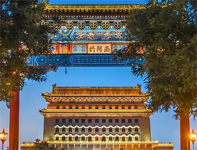 Zhengyangqiao Archway at Dashilar illuminated at night, symbolizing Old Beijing culture and heritage food traditions.