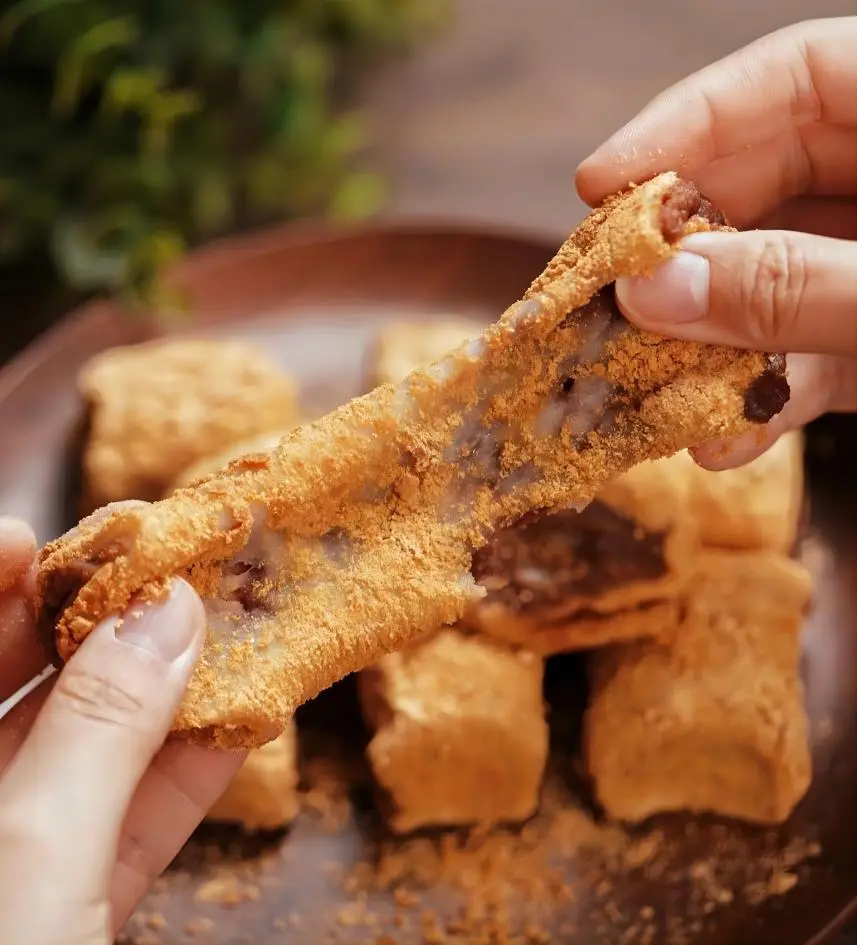 Lüdagun (Rolling Donkey) Beijing dessert, glutinous rice roll with red bean paste and yellow soybean flour