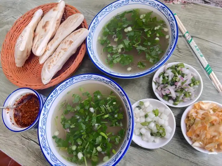 Shui Pen Yangrou Xi’an breakfast, large bowl of mutton soup with crescent flatbread and side dishes