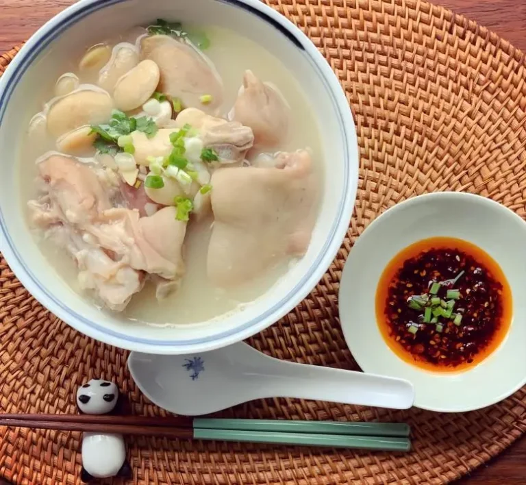 Close-up of Chengdu specialty Tihua Soup, rich pork trotter broth served in night market with authentic Sichuan flavor