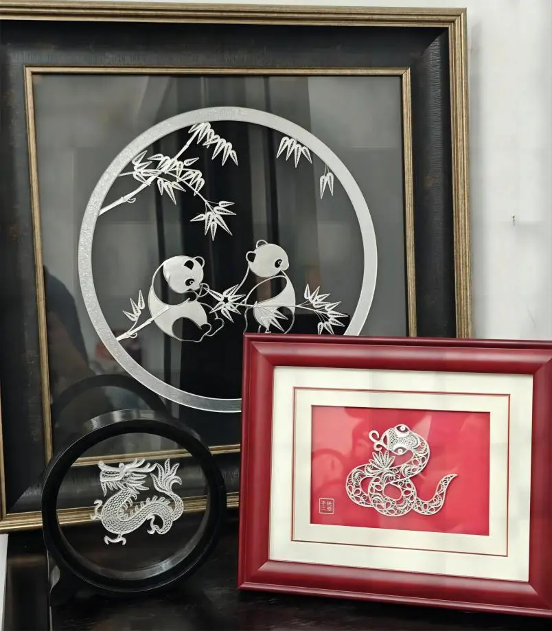 Silver wire artwork featuring a panda and dragon from Chengdu, created in Traditional Handicraft Workshops in China