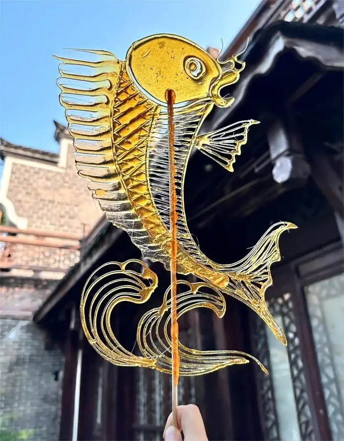 Visitor holding a fish-shaped sugar painting in Chengdu, a hands-on experience from Traditional Handicraft Workshops in China