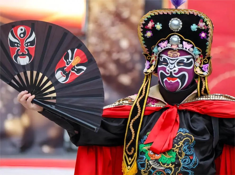 Actor performing Sichuan Opera face changing mask transition on stage in Chengdu