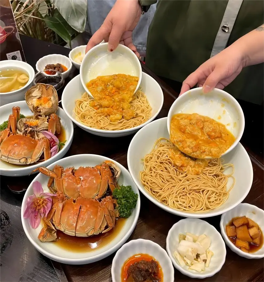 Tourist mixing Crab Roe Noodles, a seasonal Shanghai Local Food specialty