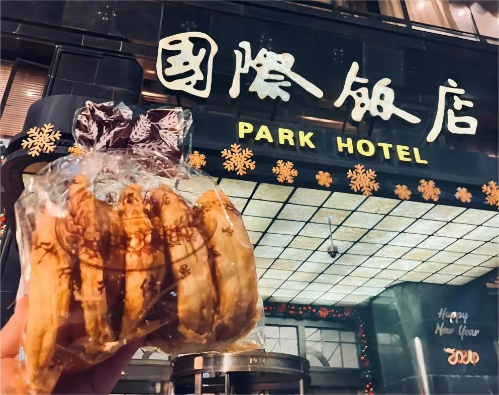 Visitor holding Butterfly Cookie in front of Park Hotel on Huanghe Road Shanghai