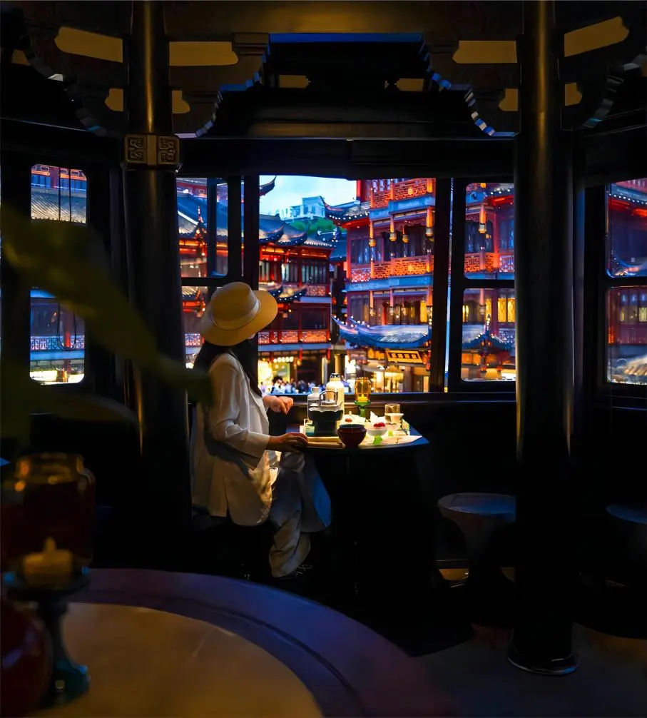 Visitors enjoying tea inside the Mid-Lake Pavilion at Yuyuan Garden, looking out over the pond and bridges
