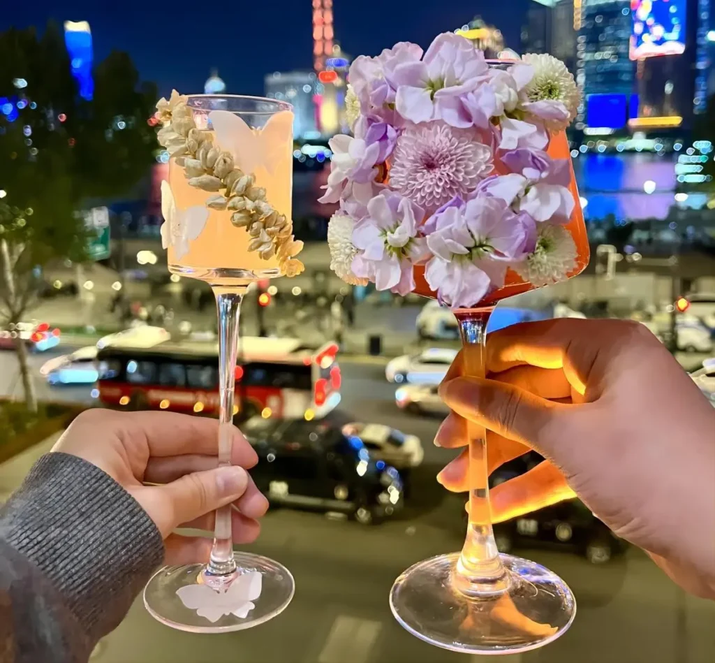 Urban China Travelogue: The Shanghai Huangpu River at night, with neon lights reflecting on the water as travelers toast and enjoy the vibrant city skyline.