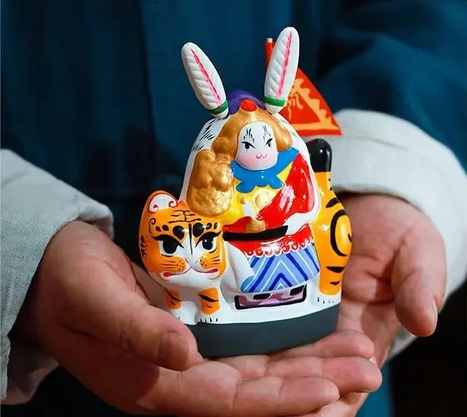 Artisan presenting a Tu’er Ye Beijing Sitting Tiger figure, a symbol of Beijing folk culture.