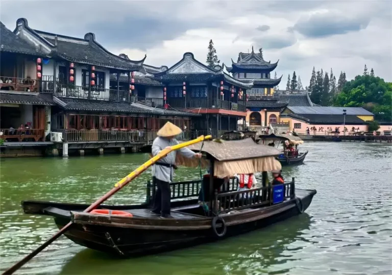 Panoramic view of tourists rowing boats through Zhujiajiao Water Town canals.