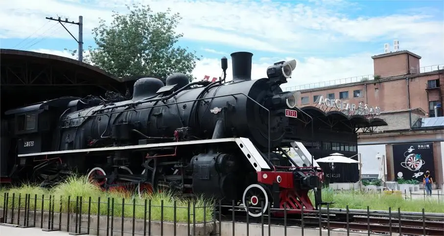 Outdoor scene of Locomotive Plaza in the Beijing 798 Art Zone, featuring preserved industrial train elements and artistic installations.