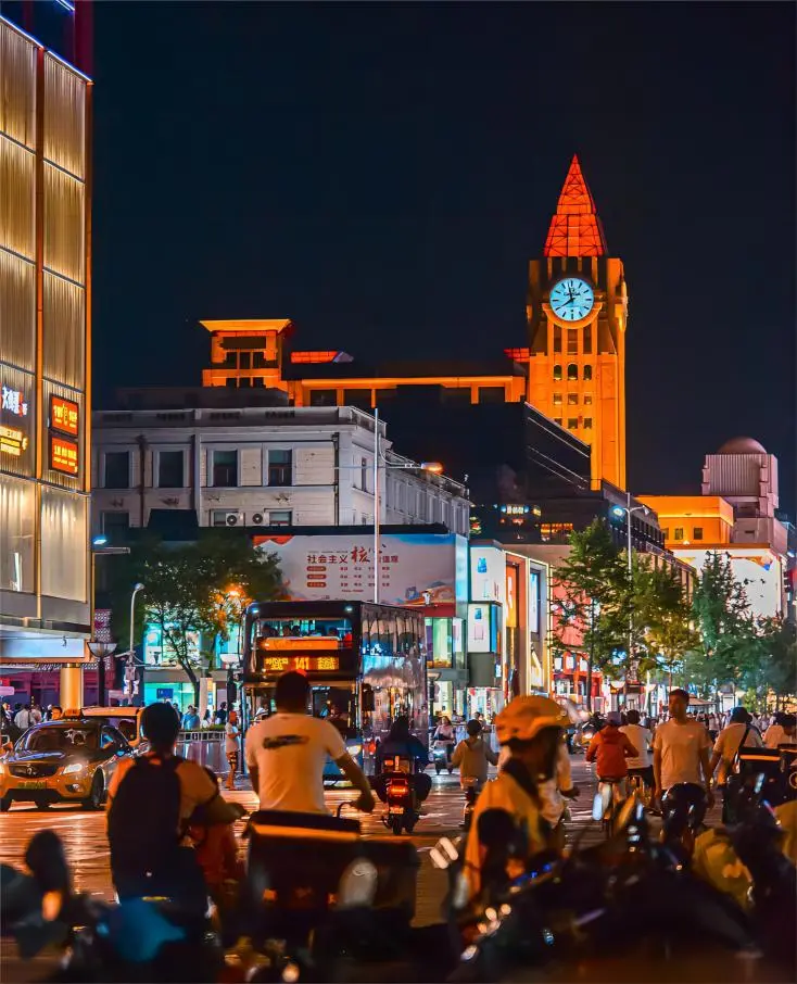 Evening scene of Wangfujing Street in Beijing, showcasing illuminated shops and bustling nightlife.