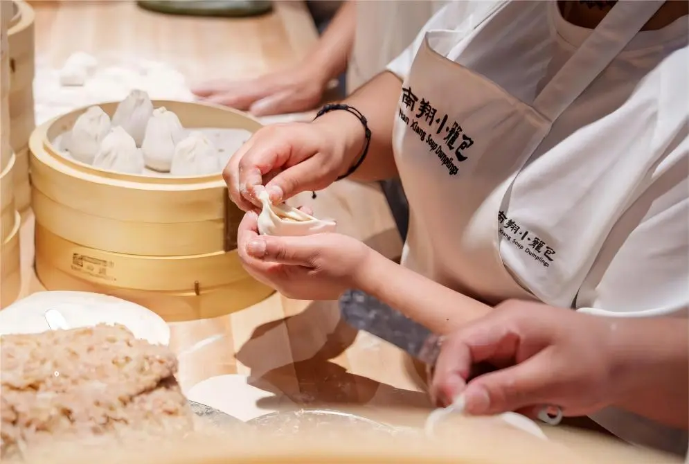 Chef crafting fresh Nanxiang Xiaolongbao in Shanghai kitchen