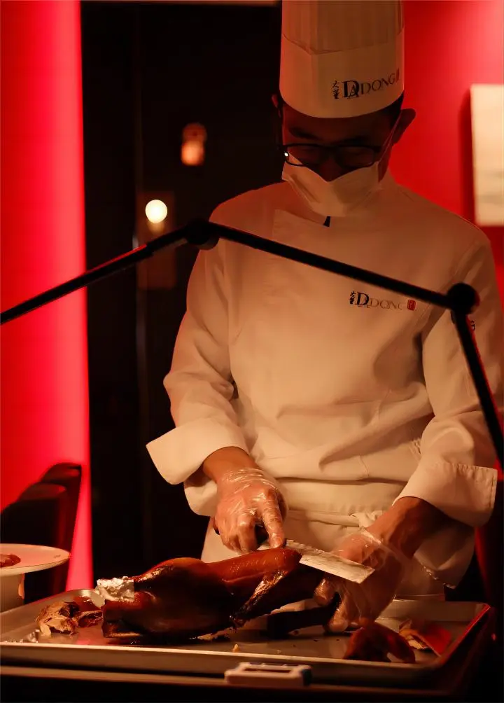 Chef slicing Peking Duck at Dadong restaurant in Beijing