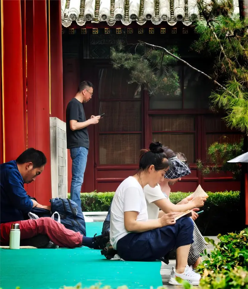 Visitor reading Buddhist sutras on the stone steps of Guangji Temple, capturing the spirit of calm reflection.