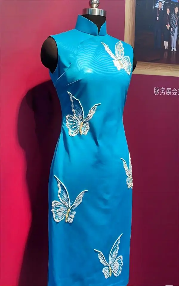 Blue Haipai Qipao displayed at Shanghai exhibition, featuring detailed embroidery and Oriental modernity