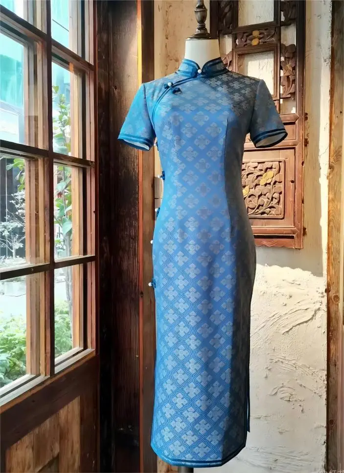 Blue Haipai Qipao displayed in Shanghai lane shop window, showcasing Shanghai Style Cheongsam elegance
