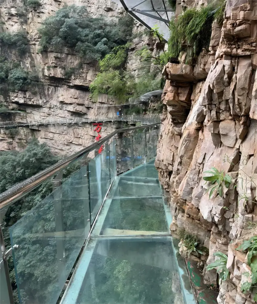Close-up view of visitors walking on the glass walkway at Jingdong Grand Canyon