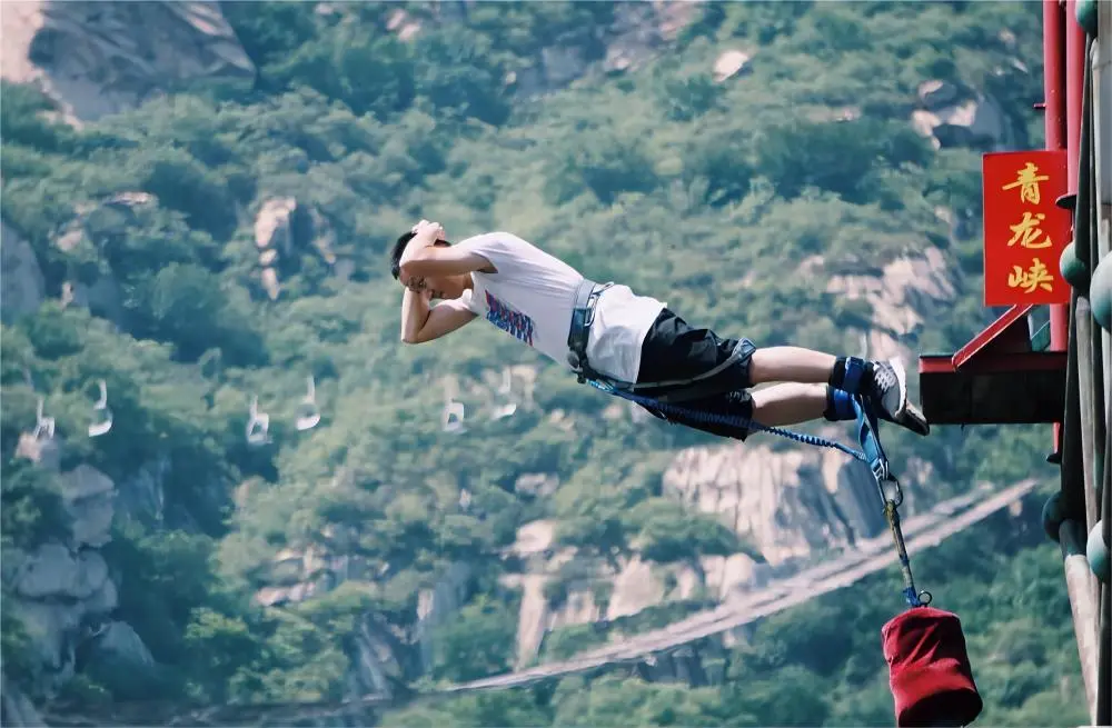 Adventure tourists bungee jumping at Qinglong Gorge