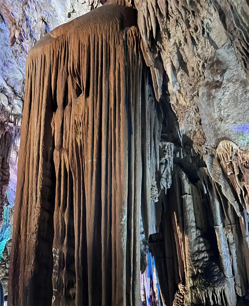 The Soaring Waterfall scene inside Stone Flower Cave, where water and stone blend harmoniously to create a stunning underground cascade.