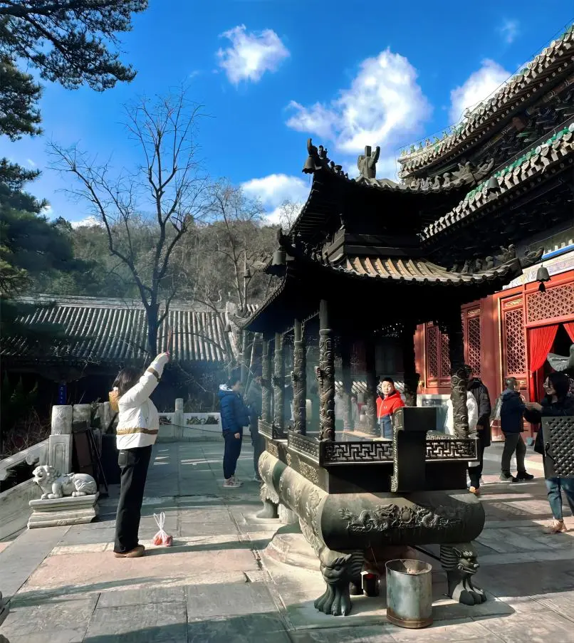 Devotee praying at Tanzhe Temple, experiencing traditional incense rituals