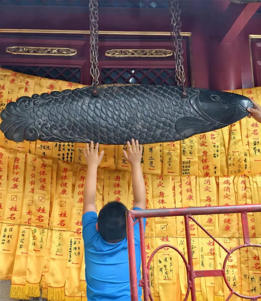Child touching the Stone Fish at Dragon King Hall, Tanzhe Temple