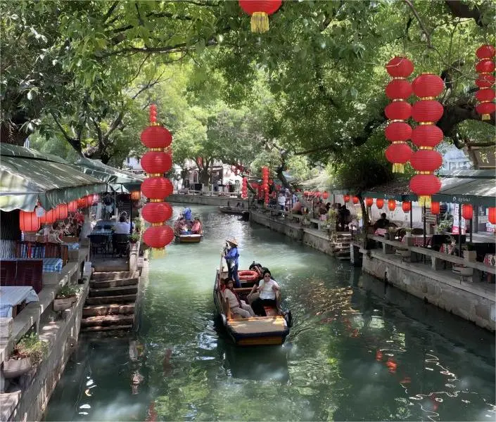 Traditional wupeng boat gliding through the canals of Tongli Water Town from Shanghai.