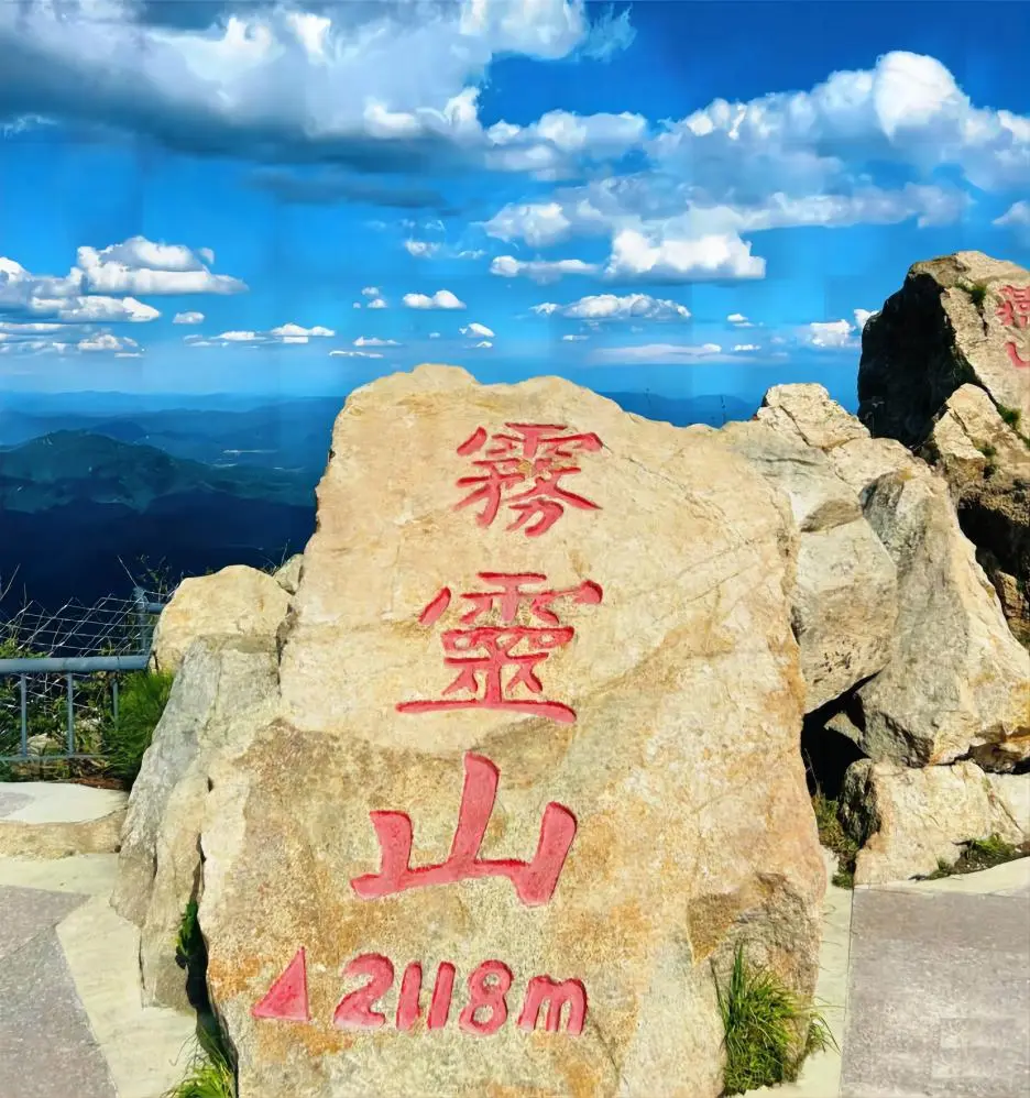Summit of Wulingshan Mountain at 2,118 meters in Beijing, marked with elevation sign, offering panoramic mountain views.