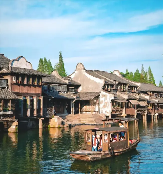 Traditional black-awning boat gliding through Wuzhen’s sunny canals, a signature experience on a Wuzhen day trip from Shanghai.
