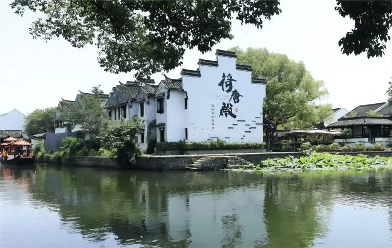Daytime canal scenery of Xitang Water Town from Shanghai, featuring traditional riverside houses.