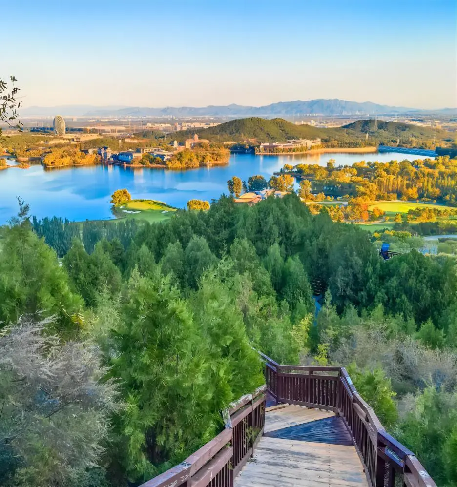 Walking path along Yanqi Lake in Beijing, offering visitors a serene lakeside stroll amid natural beauty.