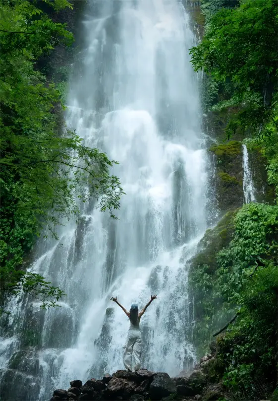 The Yin-Yang Pool Waterfall in Chengdu Hongkou Nature Reserve cascading over rocky cliffs amid a lush gorge.