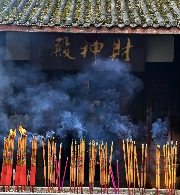 Visitors lighting incense at the God of Wealth Temple on Mount Zhaogong, creating a vibrant, spiritual atmosphere.
