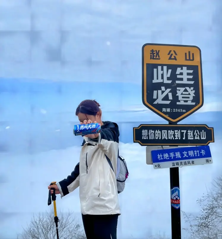Hikers reaching the summit of Zhao Gongshan, enjoying the panoramic mountain views and fresh alpine air.