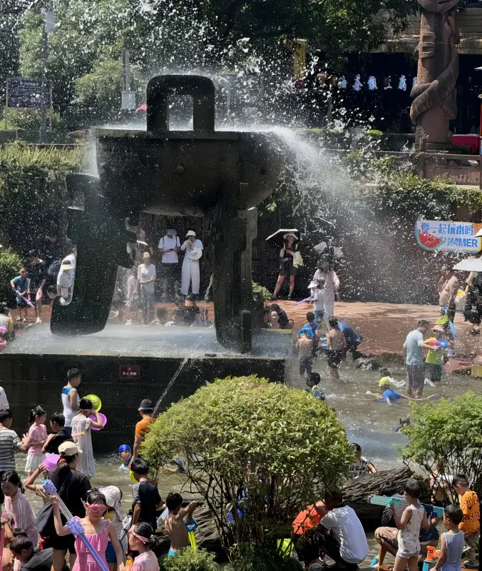 Locals and visitors enjoying summer water play in Huanglongxi Ancient Town, a popular day trip from Chengdu