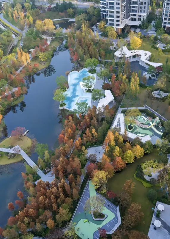 Aerial view of Luxelakes Red Sandstone Park showing the lake and green urban landscape