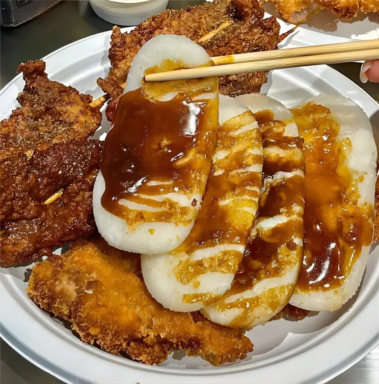 Close-up of Shanghai Paigu Niangao (pork chop with rice cakes) showing crispy pork and chewy rice cakes