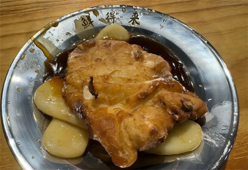 Delicious Shanghai Paigu Niangao on a plate, featuring golden crispy pork and tender chewy rice cakes