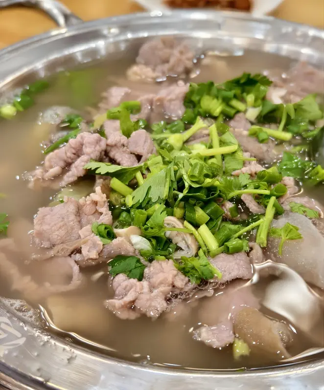 Platter of Qiao Jiao Niu Rou in Leshan, featuring tender beef and flavorful herbal broth, ready to serve