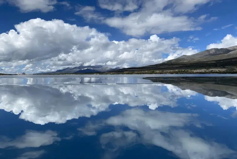 Snow-capped mountains surrounding Si Ding Cuo Sacred Lake on a clear day