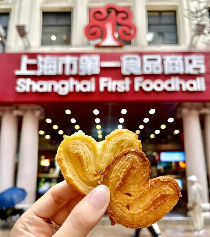 Tourist enjoying Shanghai Butterfly Crisp, showcasing iconic sweet Shanghai pastries and local delicacies.