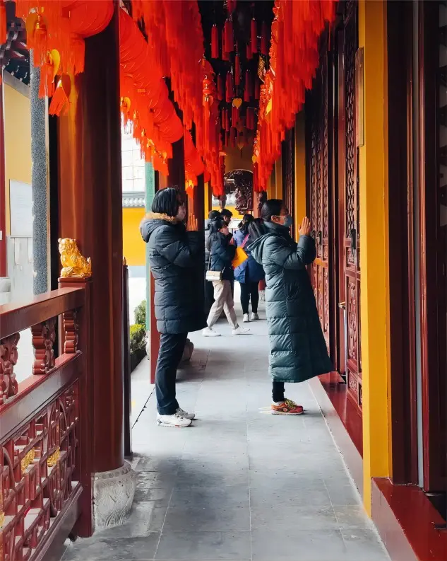 Devotees praying in front of Mazu Hall at Xiahaimiao Temple in Shanghai for safe journeys and blessings.