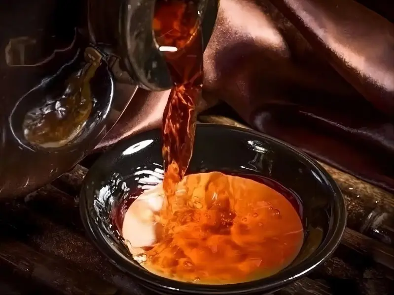 Shanghai drinks: Yellow Wine (Huángjiǔ) poured into a bowl, clear amber color showcasing Jiangnan tradition.