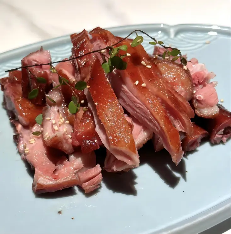 Plated Zhangcha Duck (Camphor Tea Duck) served in Chengdu, Sichuan specialty with crispy skin and tender meat