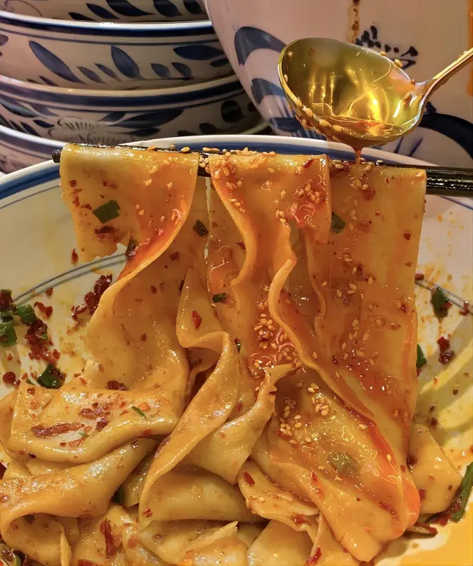 Adding chili oil to Biangbiang noodles, a classic Xi’an noodle eating style