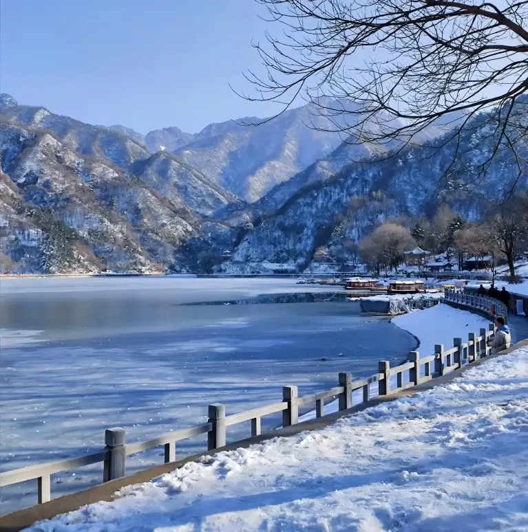 Winter scenery of Heavenly Lake in Cuihua Mountain, with snow-covered rocks and a peaceful mountain atmosphere