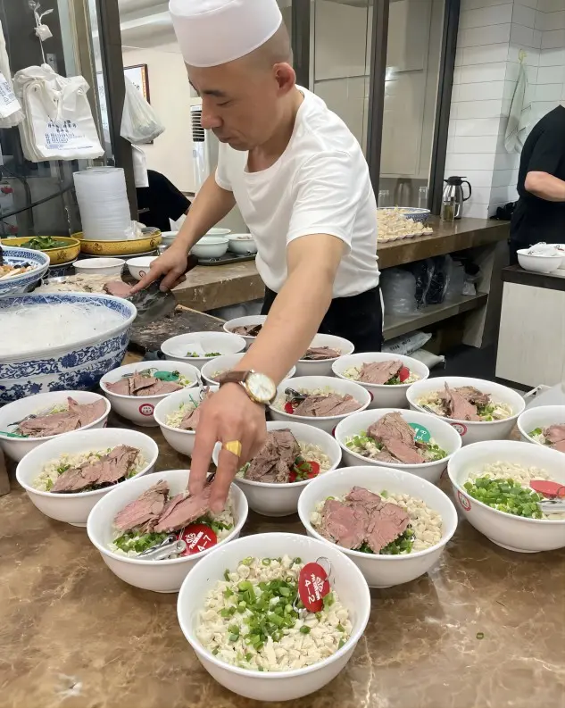 A street restaurant chef preparing traditional Xi’an Lamb Paomo in the kitchen