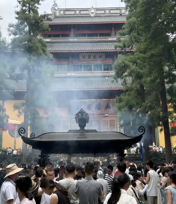 Panoramic view of the Mahavira Hall at Lingyin Temple with incense smoke and worshippers