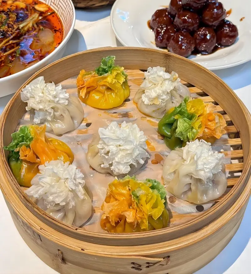 Close-up of Datong Shao Mai, delicate dumplings filled with juicy mutton or pork, shaped like pomegranates, a must-try local snack.