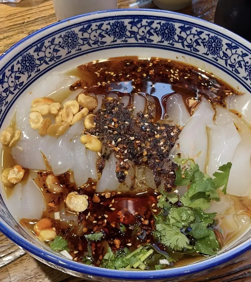 A refreshing dish of Hunyuan Liangfen, silky green bean jelly served cold with chili oil and vinegar, a popular snack in Datong.